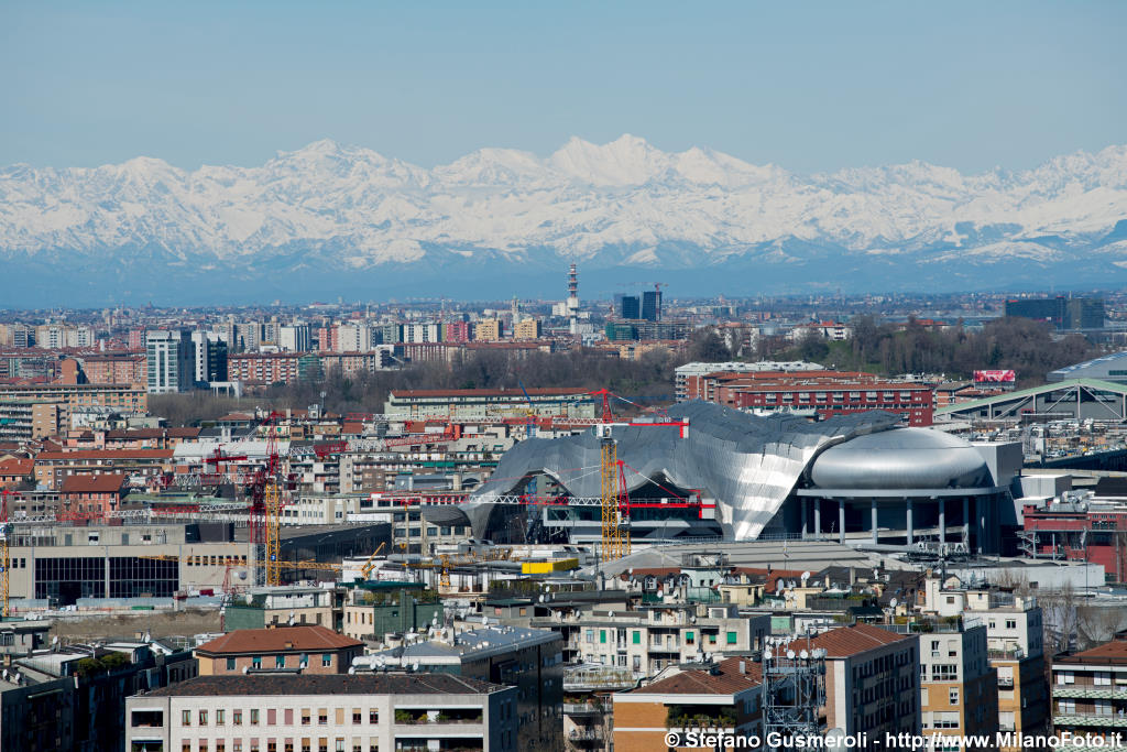  Distesa di tetti, MiCo e alpi innevate - click to next image